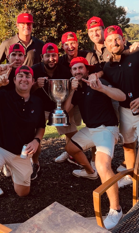 Team Dooley celebrating with the Cup in red caps at sunset