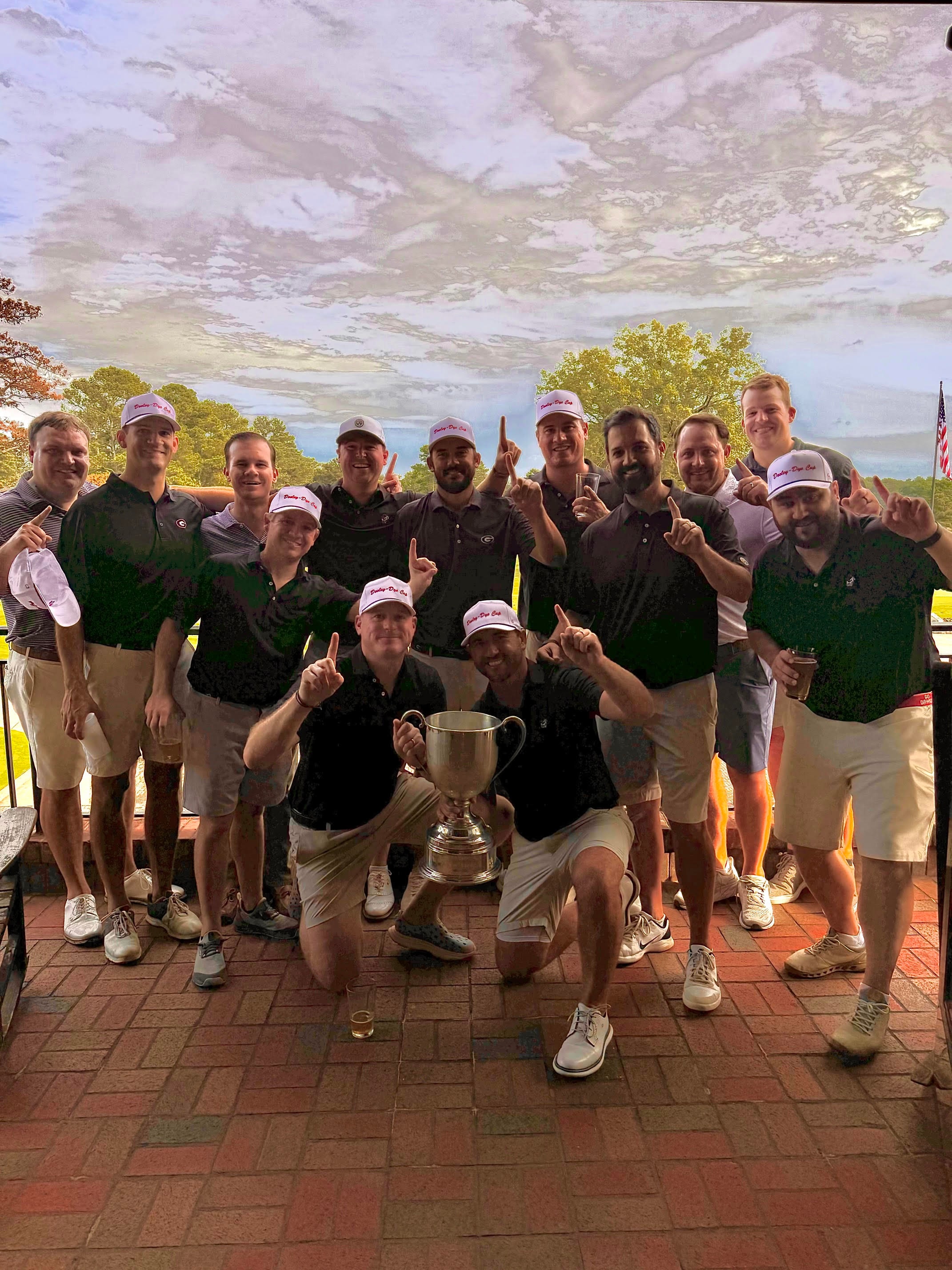 Team Dooley celebrating with the Cup in white Dooley-Dye Cup caps on the patio