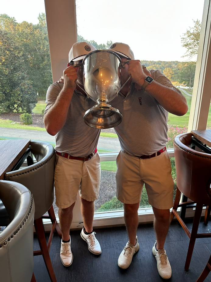 Player drinking from the Dooley-Dye Cup trophy indoors