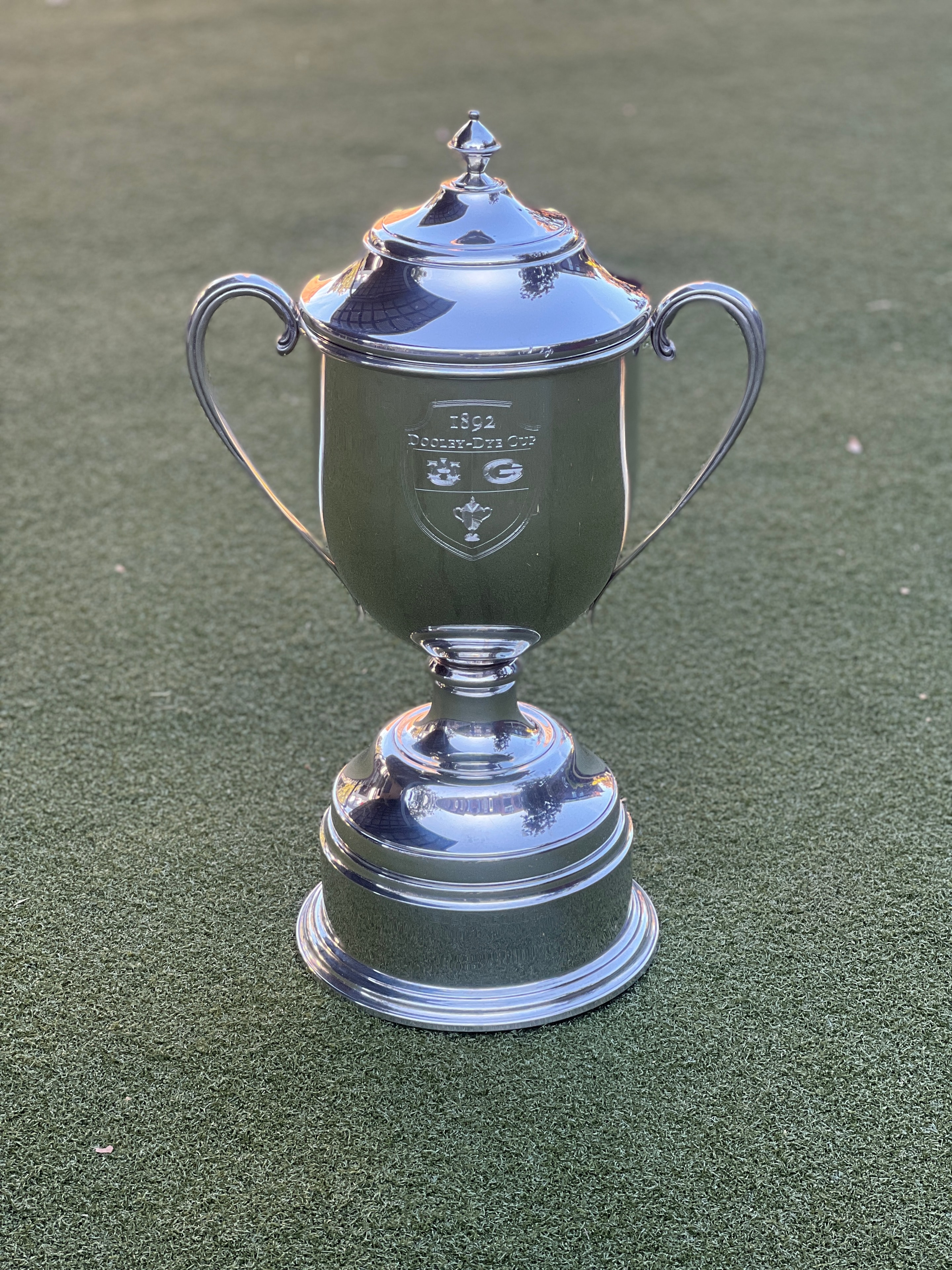 The Dooley-Dye Cup trophy standing alone on the putting green